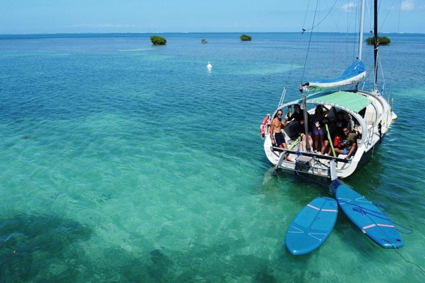 A boat with people on a clear blue sea, surrounded by small islands. 2