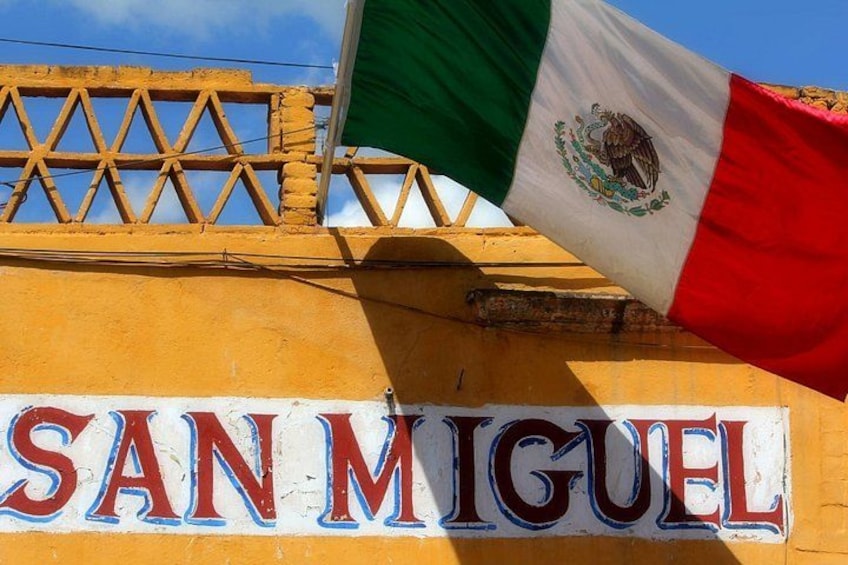 Un edificio con un letrero que dice 'SAN MIGUEL' y una bandera mexicana. 2
