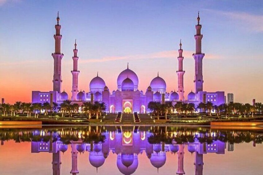 A mosque with multiple domes and minarets, surrounded by palm trees and a reflecting pool. 5