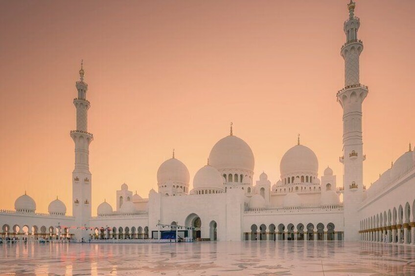 A grand mosque with multiple domes and minarets, expansive courtyards, and a reflective floor. 3