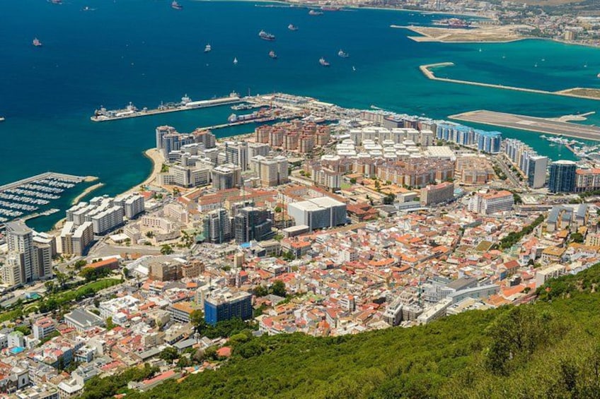 A coastal cityscape with dense urban development, a marina, and a large body of water. 4