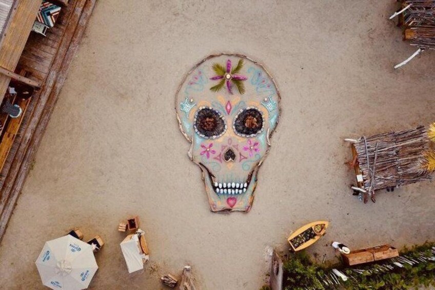 Una gran escultura de calavera decorada, rodeada de varios objetos y estructuras. 4