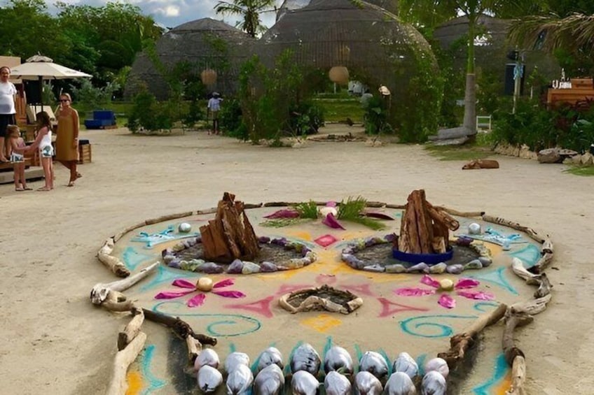 Una spiaggia con un'installazione artistica nella sabbia, dai colori vivaci, con motivi geometrici ed elementi naturali. 3