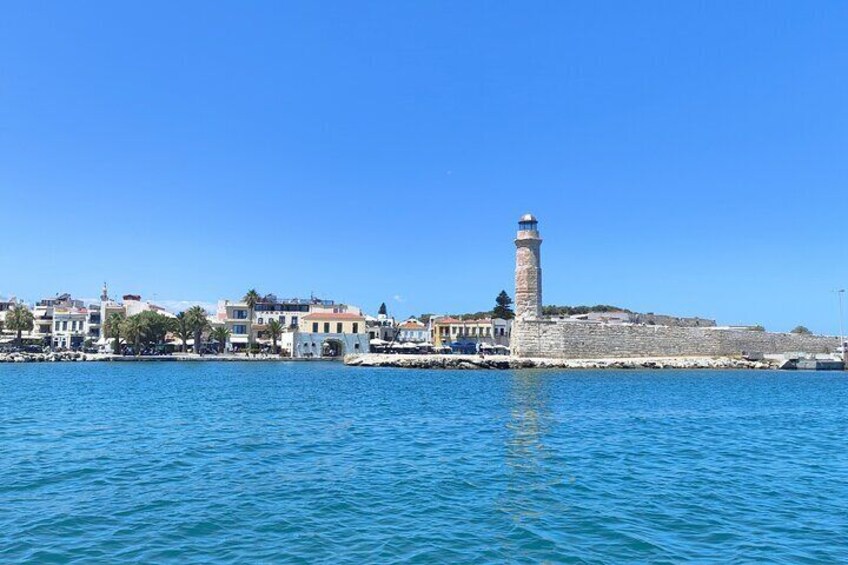 A coastal town with a prominent lighthouse, calm sea, and colorful buildings along the shore. 4