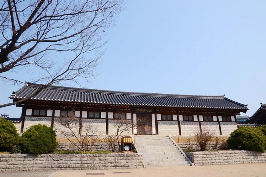 En traditionel koreansk bygning med et tag af fliser, træbjælker og en sti af sten, der fører til indgangen. 2
