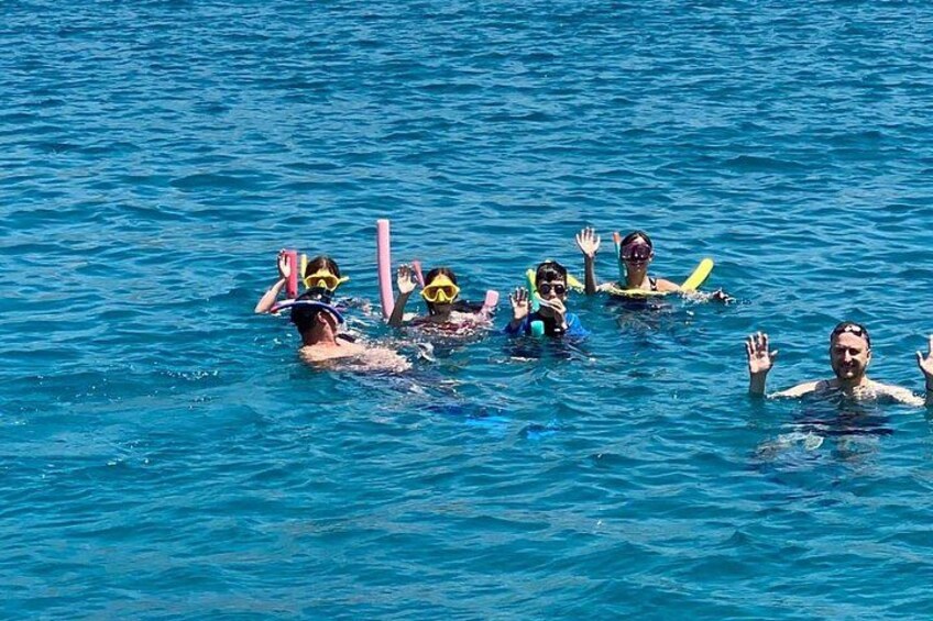 Personas nadando en el océano con snorkel y aletas. 3