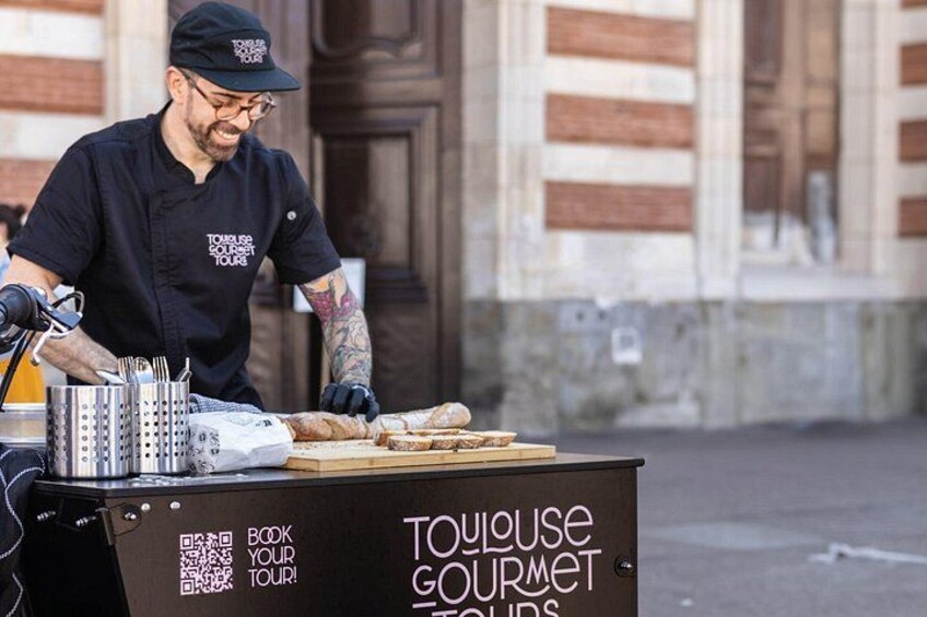 A street food vendor preparing food at a stand with a sign advertising a gourmet tour. 3