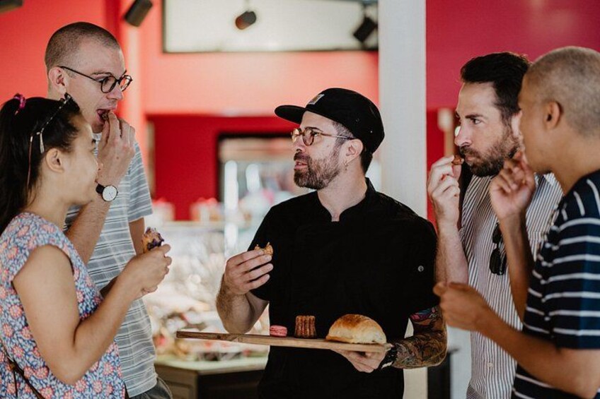 A group of people eating at a food stall with a red interior. 5