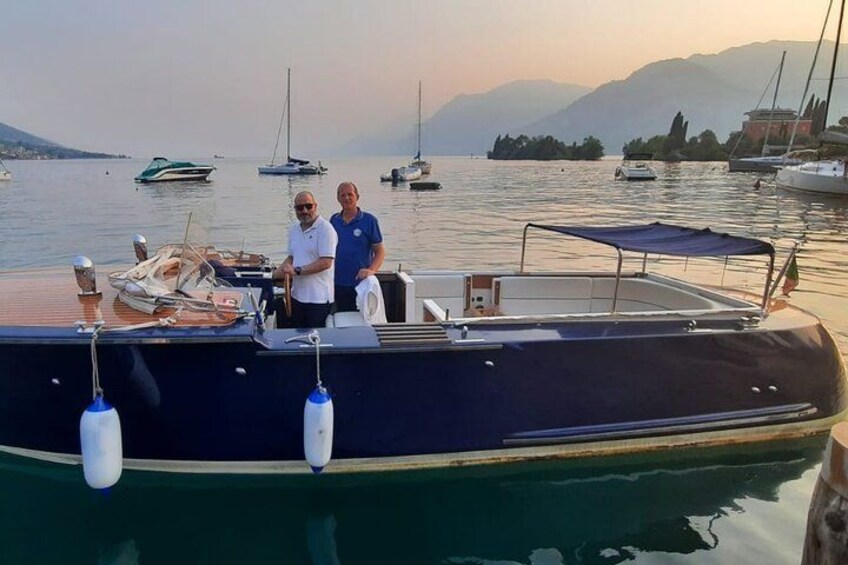 En båd ligger til anker i en lysthavn med roligt vand og både i baggrunden. 1