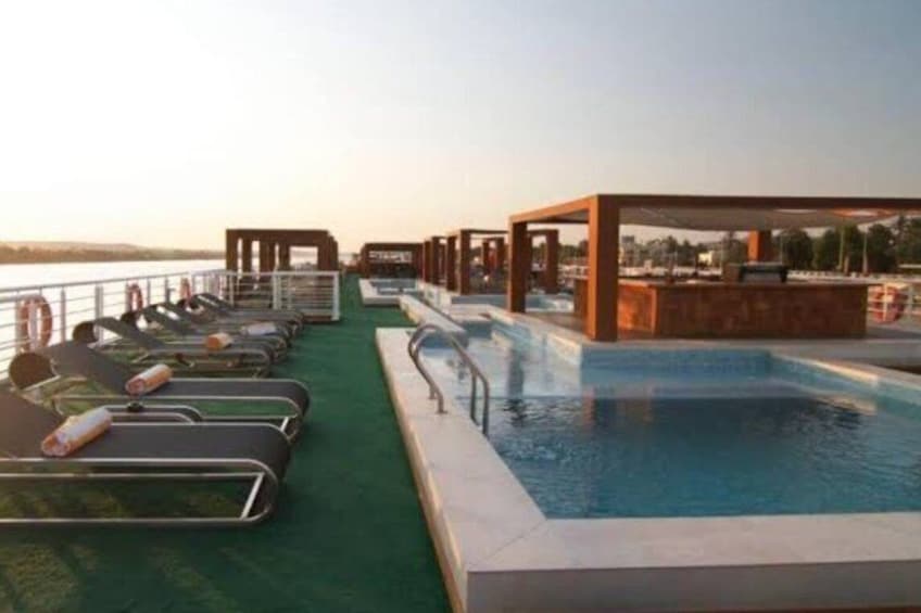 A pool area with lounge chairs and a small pool. 1