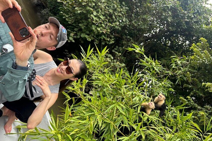 Deux personnes prenant un autoportrait avec un singe en arrière-plan. 2