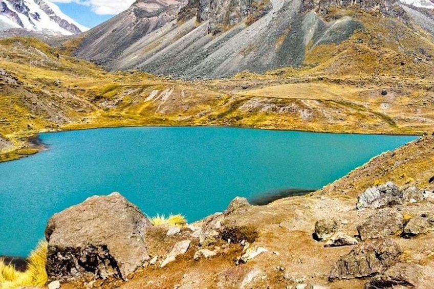 A turquoise lake surrounded by rugged mountains and rocky terrain. 4