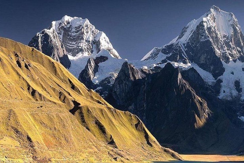 A mountain range with snow-capped peaks and a yellow-brown slope. 2