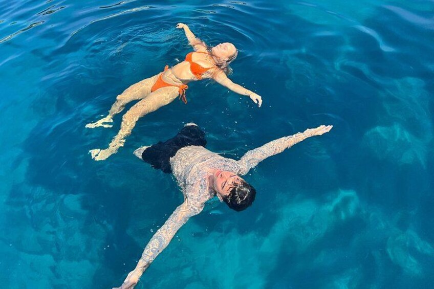 Dos personas flotando en aguas azules y cristalinas. 2