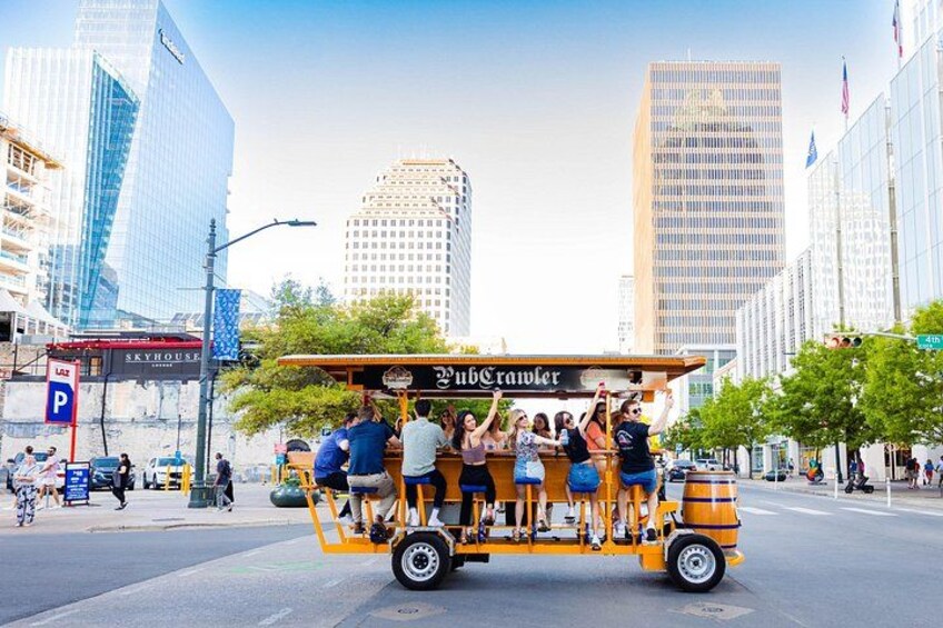 A yellow trolley with passengers, a 'Pub Trailer' sign, and city buildings in the background. 4