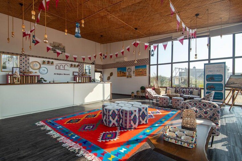 A spacious room with a large rug, patterned furniture, and a reception desk. 2