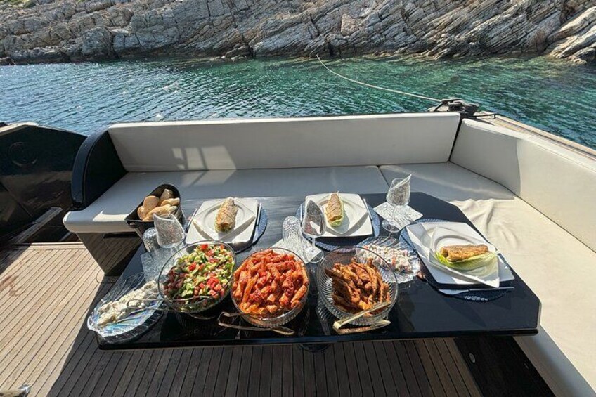 Un barco con una mesa lista para una comida, rodeado de acantilados rocosos y agua cristalina. 4