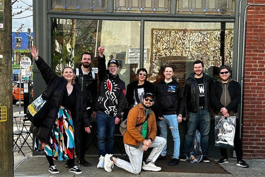 Eine Gruppe von Personen steht vor einem Gebäude mit Glastür. 5