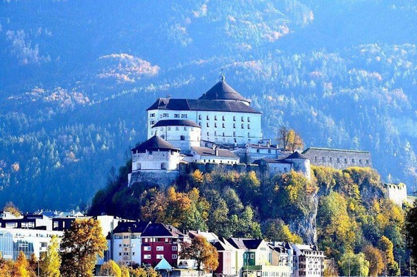 A castle on a hill with a lake in the foreground. 3