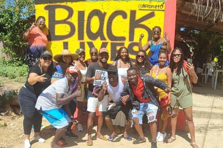 A group of people posing in front of a 'Black Lives Matter' sign. 2