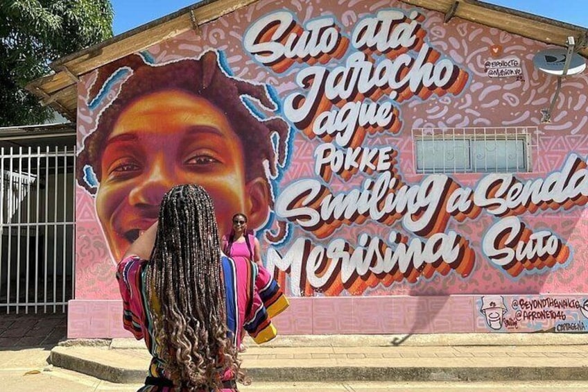 A mural with text and a person in front of it. 2