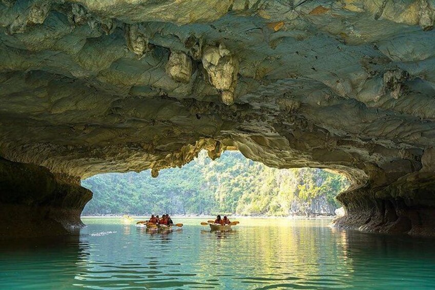 Una cueva abierta con agua y gente haciendo kayak dentro. 2