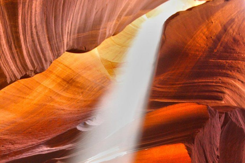 A canyon with layered rock formations and a narrow water stream. 2
