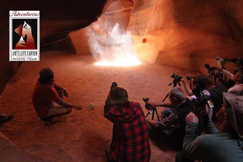 A group of people around a fire in a canyon, with cameras and tripods. 5
