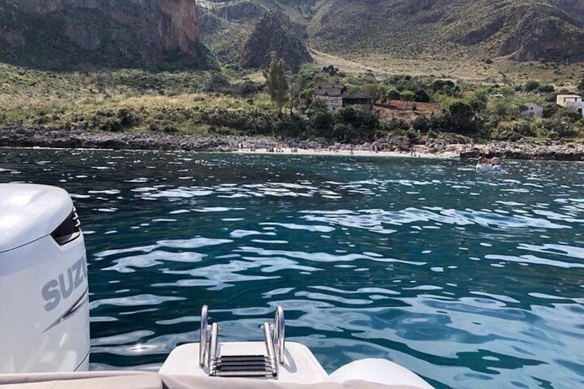 A boat on a river with a rocky riverbank and mountains in the background. 3