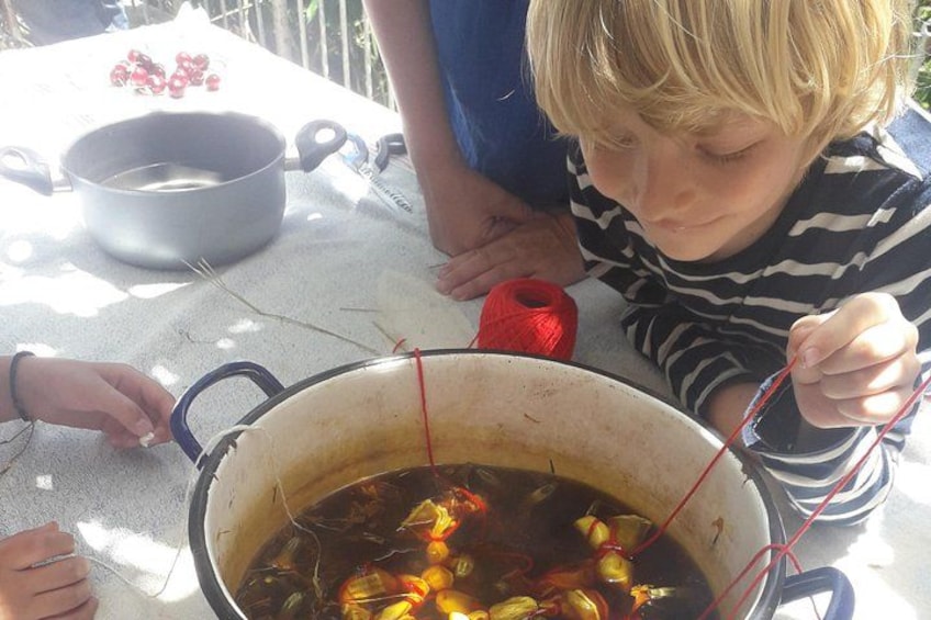 A child cooking outdoors with a pot on a table. 2