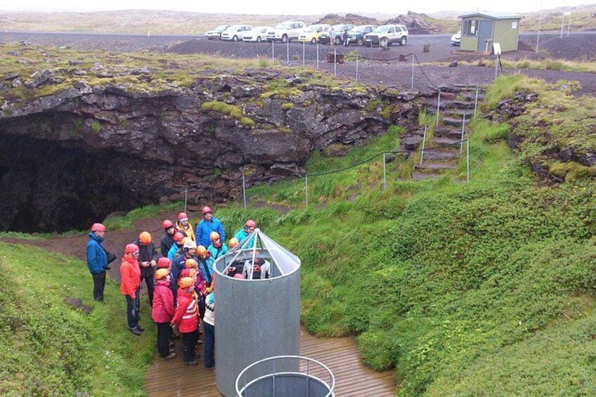 A group of people observing a geological formation with a viewing platform. 1