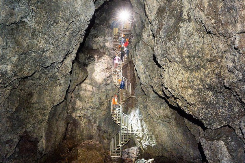 A rock formation with a staircase leading into a cave. 1