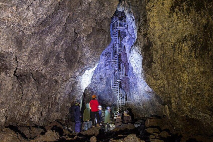 A cave with a metal staircase leading to a higher level. 3