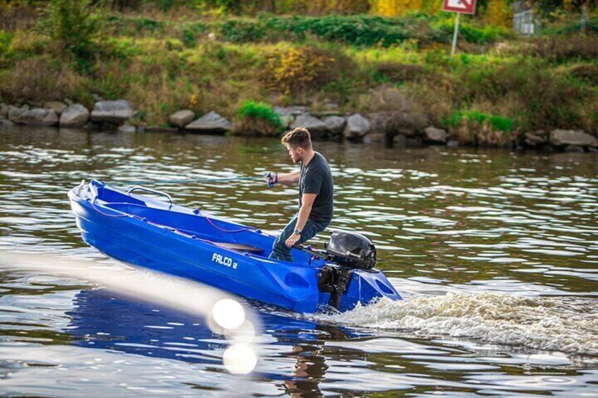 A person in a blue boat with a motor, moving on water. 4