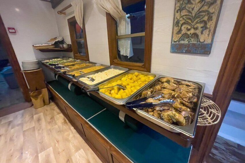 Un buffet proposant une variété de plats, notamment des fruits et des viandes, présentés dans des plateaux en métal. 4