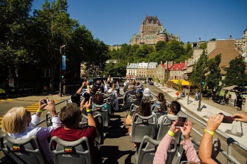 A group of people on a guided tour bus, sightseeing a historic building. 1