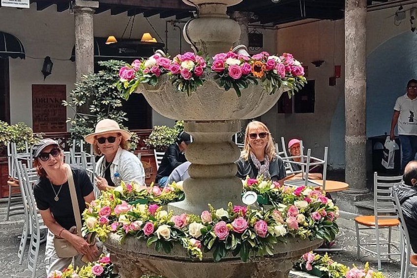 A fountain with flowers, surrounded by outdoor seating. 3