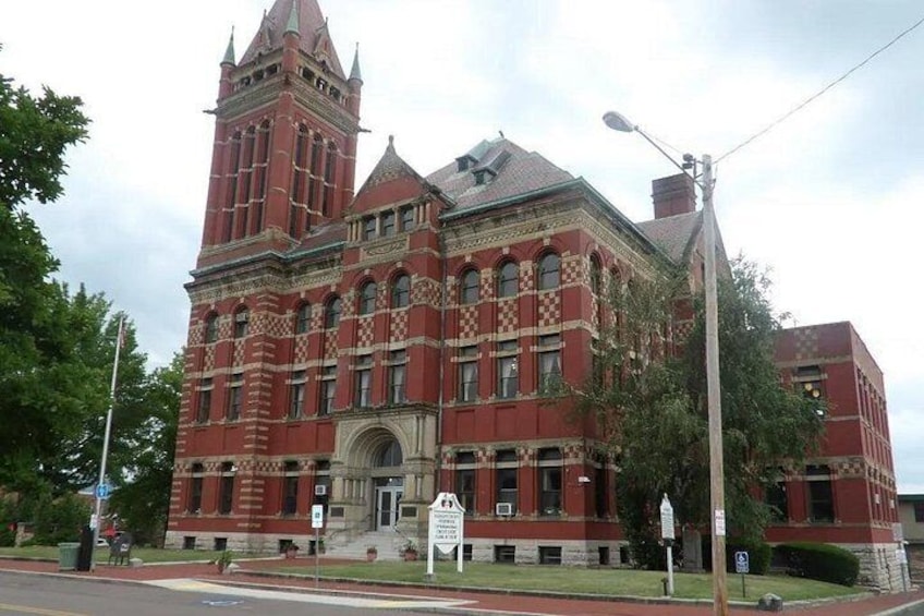 A large red brick building with a tower and arched windows. 2