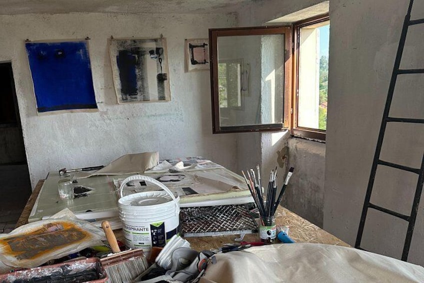 Una habitación desordenada con una mesa, un ventanal y una escalera. 1