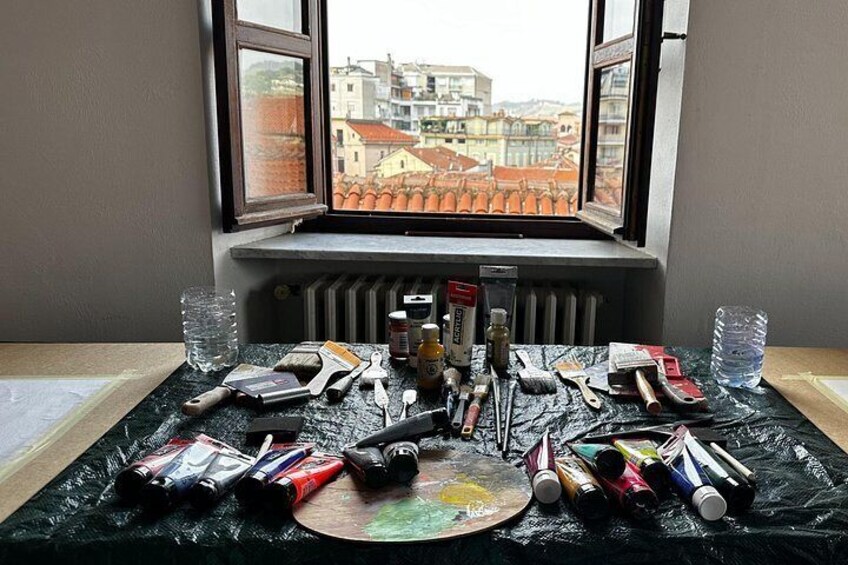 Una mesa con material de arte, una ventana y un radiador. 1