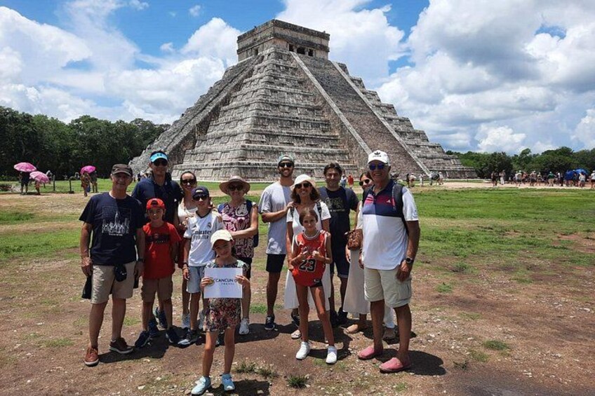 Un grupo de personas frente a una gran estructura piramidal. 1