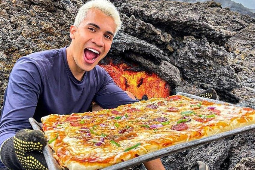 A person holding a large pizza with various toppings. 2