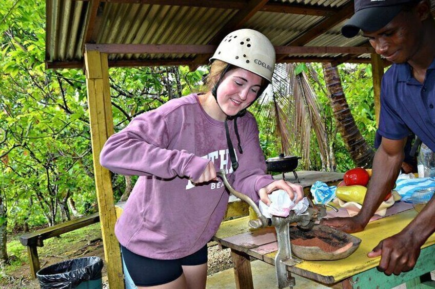 A person wearing a helmet and a purple shirt, working with a tool on a wooden table outdoors. 1