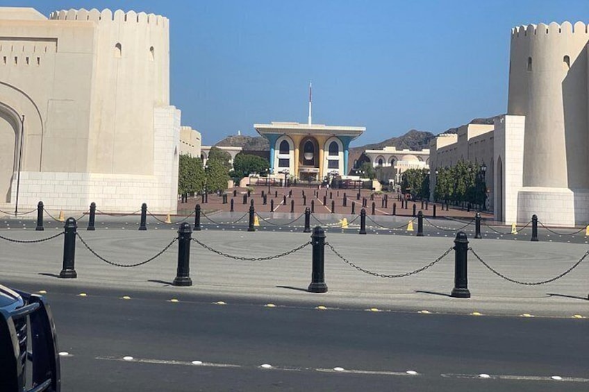 A paved area with a central building, two large towers, and a chain barrier. 4