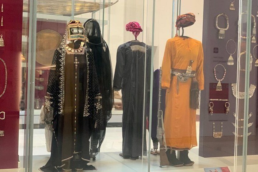 Mannequins in traditional attire, jewelry, and a red book. 5