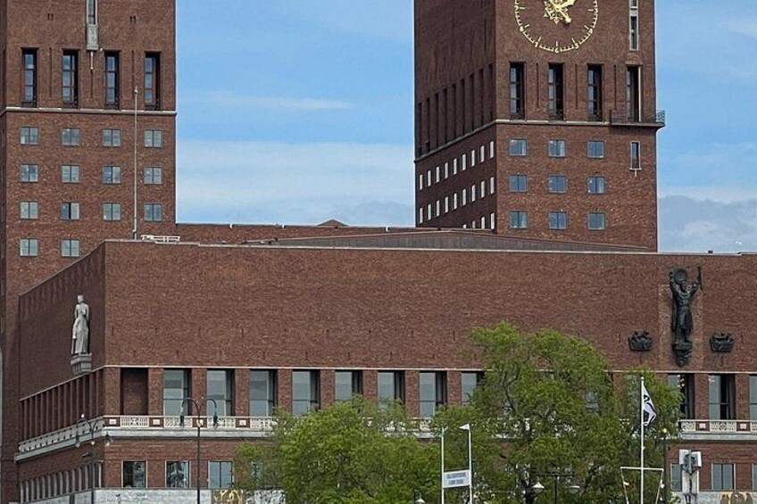 Ein großes Backsteingebäude mit einem Glockenturm, einer Statue und einer Flagge. 3
