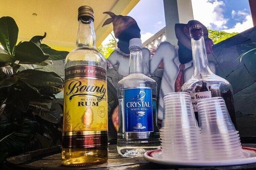 Botellas de ron Bounty y ron Crystal White, vasos de plástico y un plato sobre una mesa. 5