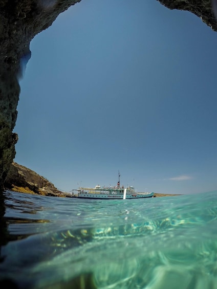 Una barca chiamata 'Hornblower' ancorata nei pressi di una costa rocciosa. 1