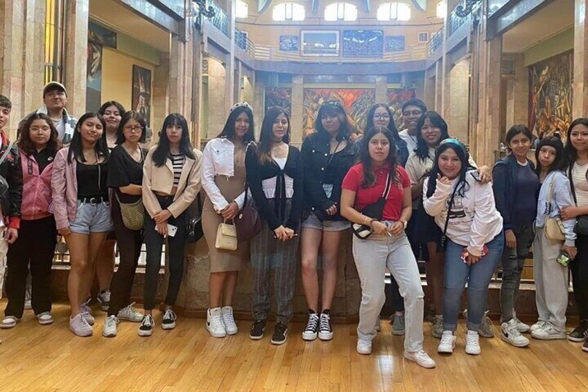 Un grupo de personas posando para una foto en un edificio con pisos de mármol y decoraciones elaboradas. 5