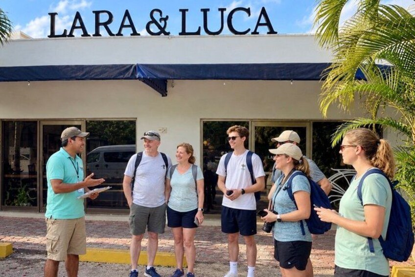 A group of people standing in front of a building with the sign 'LARA & LUCA'. 3